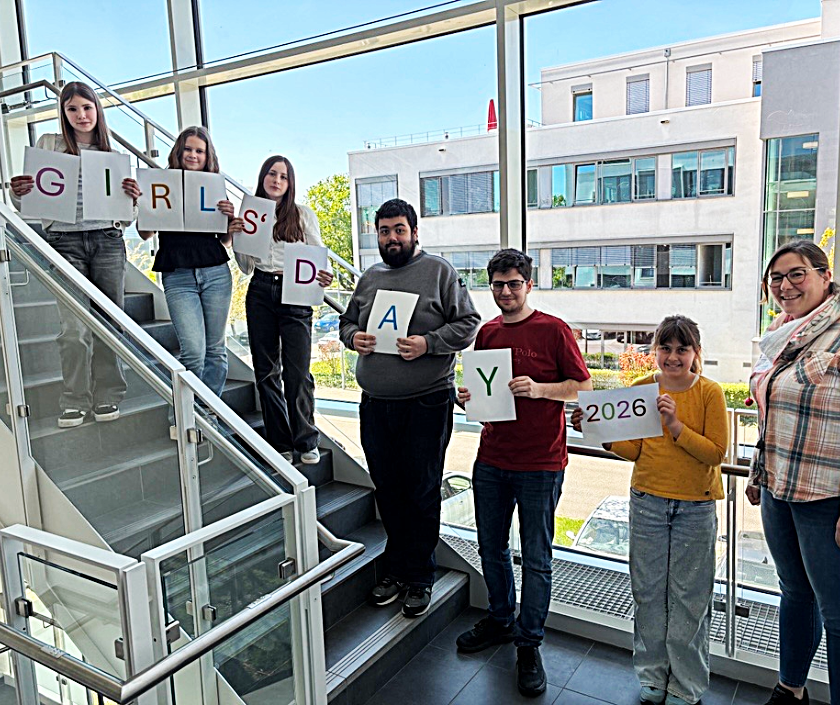 Teilnehmerinnen des Girls’ Day halten gemeinsam mit zwei Auszubildenden und der TechniData Ausbilderin Buchstabenblätter mit der Aufschrift „Girls’ Day“.